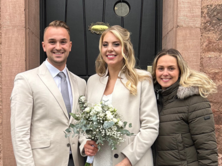 Chantal Will mit einem Brautpaar vor der Kirche