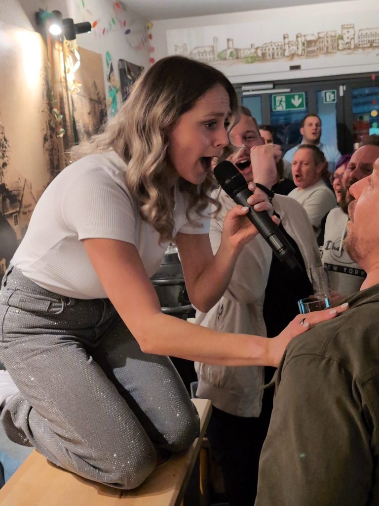 Chantal Will singt mitten im Publikum bei einer Feier
